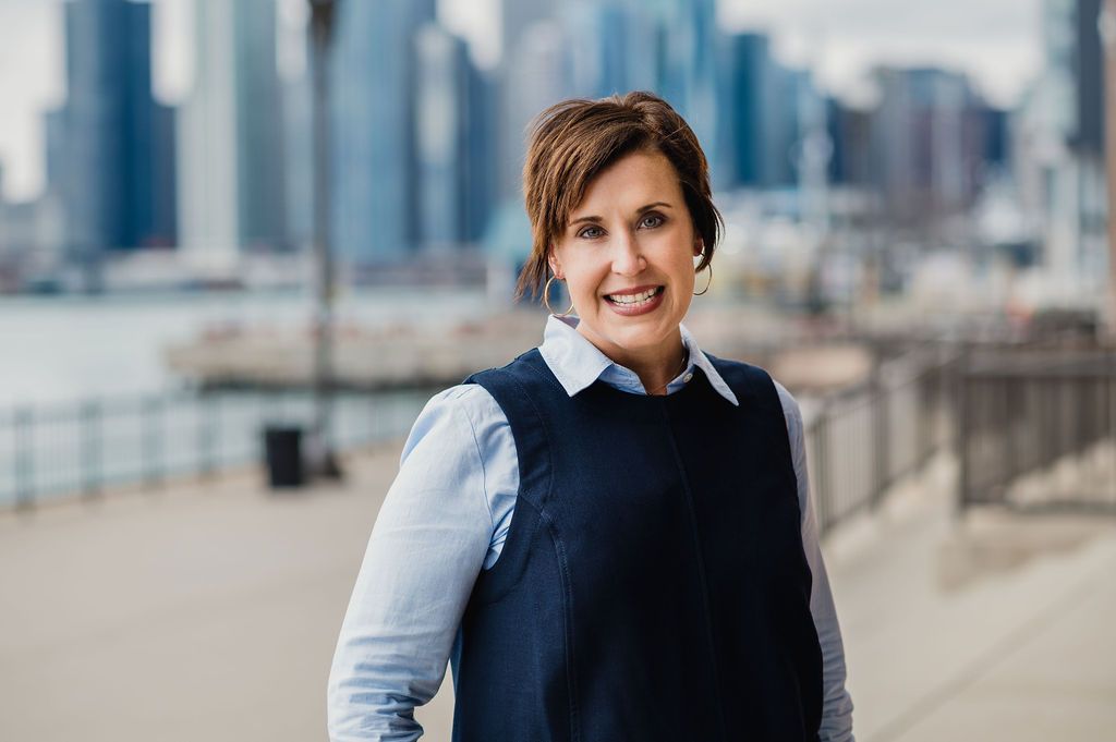 Woman smiling with skyline of Chicago in background.